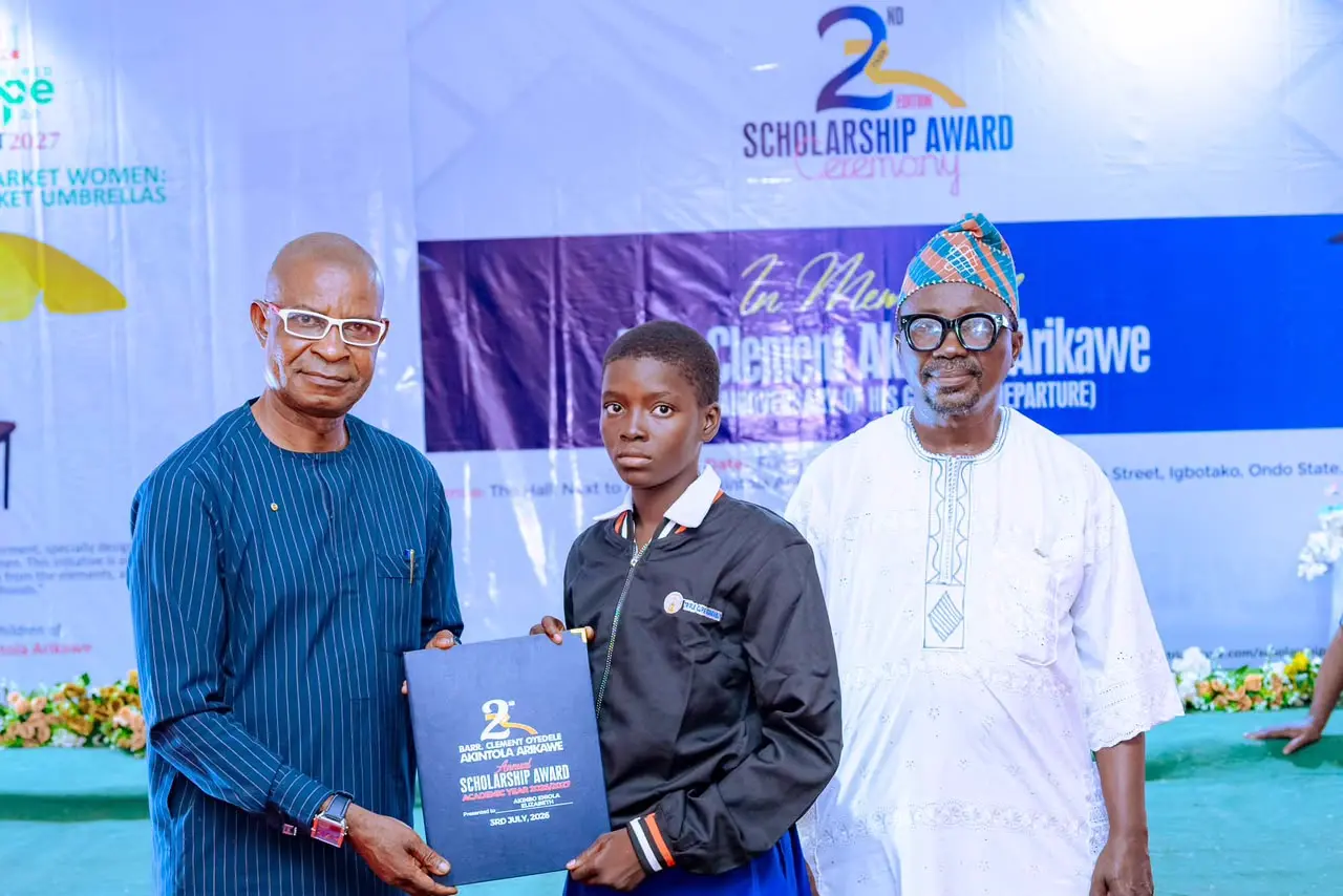 Supporting female education: A top science student receives her scholarship award on stage.